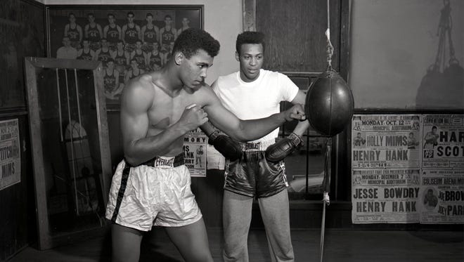 Ali punches the double-end bag at Bruner's Headline Gym as Jimmy Ellis (right) watches in background in 1961.