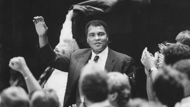 Ali waves to the crowd at a Louisville Cardinals basketball game in 1988.