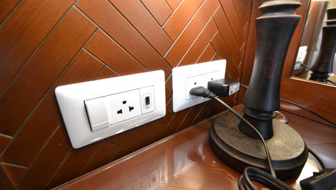 An electrical outlet and light switch is located at the side of the desk in Avalon Myanmar cabins.