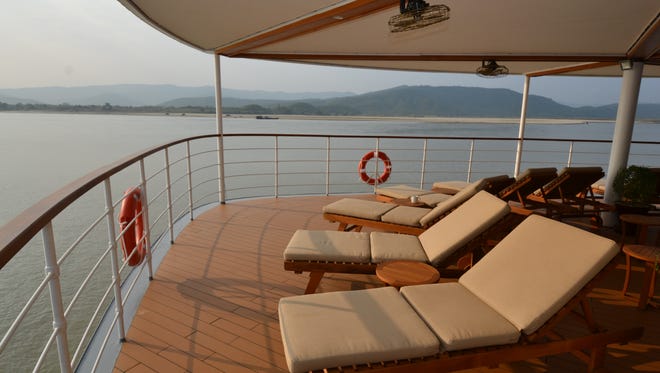 The Avalon Myanmar's open-air deck features comfortable lounge chairs overlooking the front of the vessel.