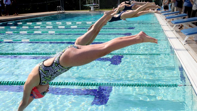 Greenfield's Alyssa Kotke and other competitors leap off the blocks to start the 100-meter freestyle during the Whitnall Falcon FunFest Invitational on Aug. 19 at the Village Club in Greendale, the season's only outdoor swim meet.