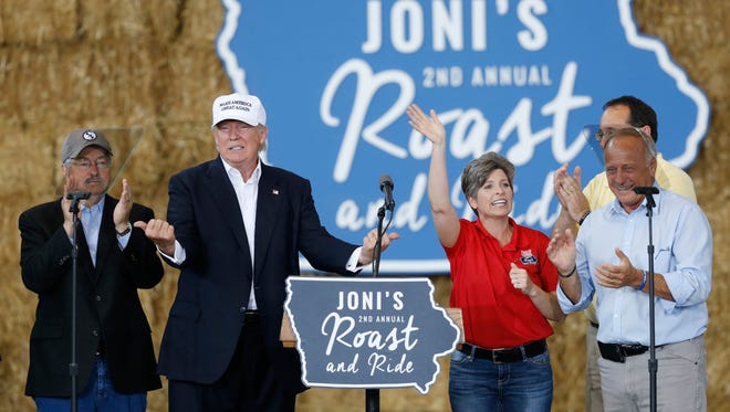 Republican presidential candidate Donald Trump points to Gov. Terry Branstad (left) and Sen. Joni Ernst Saturday, Aug. 27, 2016, as they join him on stage during the second annual Roast and Ride at the Iowa State Fairgrounds in Des Moines.