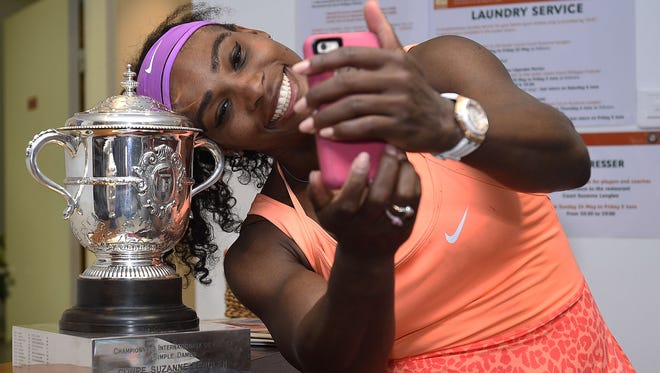 Serena Williams takes a selfie with the Suzanne Lenglen trophy following her victory over Czech Republic's Lucie Safarova after the 2015 French Open women's singles final match.