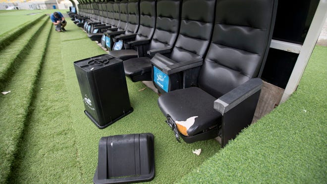 A trash can lays by ripped seats in one of the dugouts in Maracana stadium in Rio de Janeiro, Brazil.