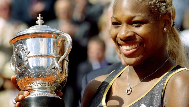 Serena Williams holds the Roland Garros French Open trophy after defeating her sister, Venus Williams in the women's final.