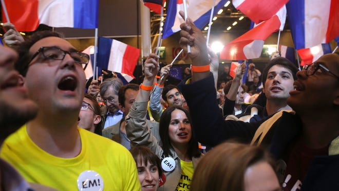 Supporters of French centrist candidate Emmanuel Macron react at his election day headquarters in Paris on April 23, 2017.