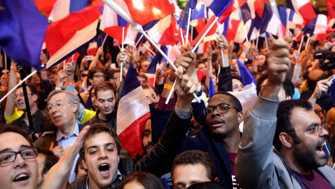 Supporters of French centrist presidential candidate Emmanuel Macron react at his election day headquarters as the first partial official results and polling agencies projections are announced in Paris on April 23, 2017. Pollsters projected that pro-Europe centrist Emmanuel Macron and far-right populist Marine Le Pen both advanced Sunday from the first round of voting in France's presidential election.