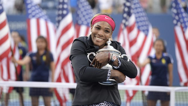 Serena Williams hugs the 2014 U.S. Open trophy after beating Caroline Wozniacki in the women's singles final.