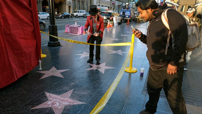 A man takes a photo of the vandalized star on Oct. 26, 2016, in Los Angeles.