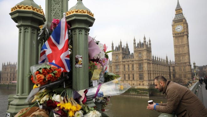 Flowers are left on Westminster Bridge by the Houses of Parliament in memory of those who died in last week's terror attack.