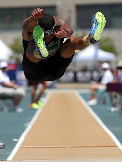 Devon Williams stretches for the pit in the decathlon long jump. Williams jumped 7.74 meters and led after two events.