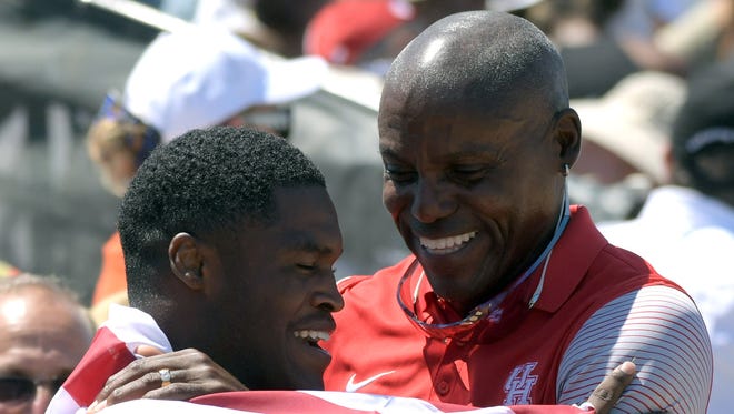 Elijah Hall-Thompson of Houston (left) celebrates with Houston Cougars assistant coach Carl Lewis after placing third in the 200.