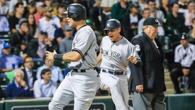 New York Yankees outfielder Jacoby Ellsbury (R) and New York Yankees outfielder Aaron Judge (L) celebrate as they both score on a double hit by New York Yankees designated hitter Gary Sanchez in the eighth inning of their MLB game against the Chicago White Sox.
