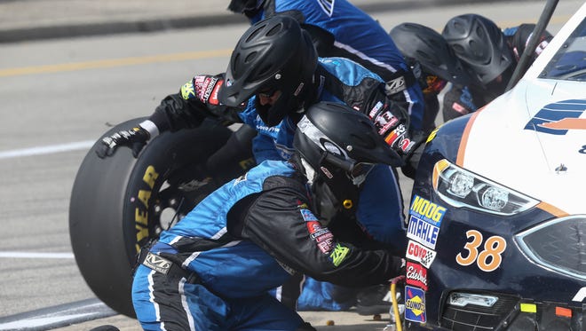 Landon Cassill's pit crew change tires on the No. 38 Ford at Michigan International Speedway.