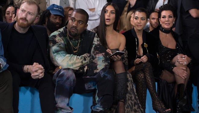 Kanye West (2-L) and Kim Kardashian (C) during the Paris Fashion Week a few days before an armed robbery at her luxury apartment in Paris on Oct. 3.