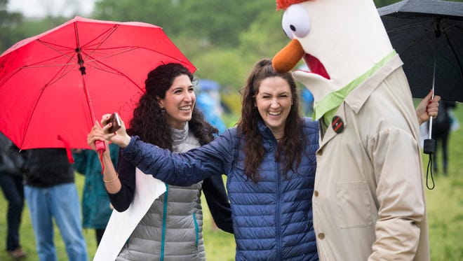 Alexa Sisk and Raha Hakimdavar laugh after taking a selfie with a marcher dressed as Beaker, the scientist Muppet, at the March for Science in downtown Washington.