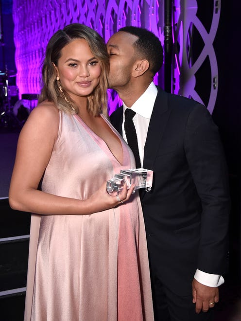 Legend kisses Teigen -- pregnant with their second baby!-- at City Harvest's 35th Anniversary Gala in April 2018. They welcomed baby No. 2, Miles Theodore Stephens, the next month.