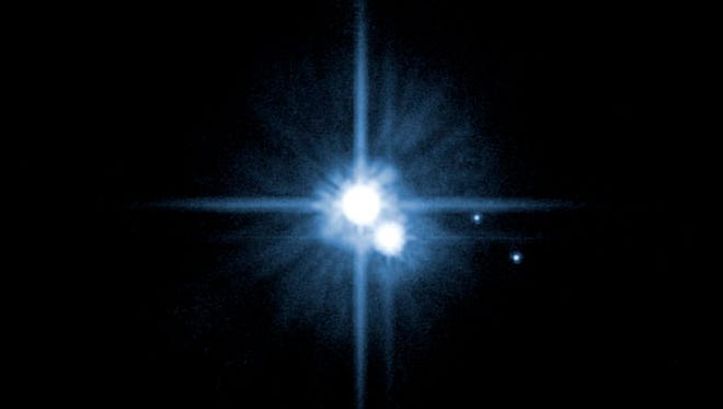 FILE - This file image provided by NASA on Feb. 22, 2006 from it's Hubble Space Telescope shows Pluto and three of it's five moons.  An online vote to name Pluto's two newest, itty-bitty moon concluded Monday, Feb. 25, 2013, and the winner is Vulcan, a name suggested by actor William Shatner, who played Capt. Kirk in the original "Star Trek" TV series.  (AP Photo/NASA, File) ORG XMIT: NY116
