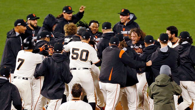 Game 3 in San Francisco:  The Giants celebrate after second baseman Joe Panik hit a walk-off RBI double in the 13th inning.