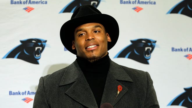 Carolina Panthers quarterback Cam Newton wears a black coat and hat as he talks with reporters during a post-game news conference after an NFL football game against the Seattle Seahawks, Sunday, Dec. 4, 2016, in Seattle.