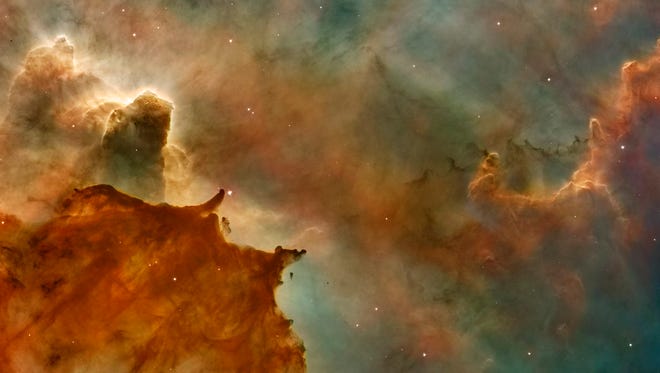 The Carina Nebula features great clouds of cold hydrogen resembling summer afternoon thunderheads. They tower above the surface of a molecular cloud on the edge of the nebula.