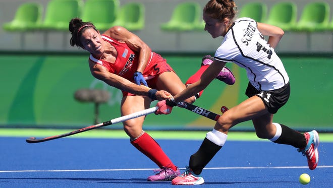 Melissa Gonzalez of the United States passes the ball against Lisa Schutze of Germany during a women's hockey quarterfinal match in the Rio 2016 Summer Olympic Games at Olympic Hockey Centre.