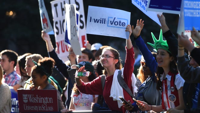 A crowd of people hold signs during an MSNBC broadcast on the campus of Washington University in St. Louis. on Oct 9, 2016, before the second presidential debate between Democratic nominee Hillary Clinton and Republican nominee Donald Trump.