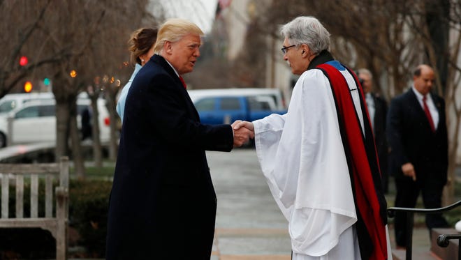 Rev. Luis Leon greets President-elect Donald Trump and his wife Melania as they arrive for a church service at St. Johns Episcopal Church across from the White House in Washington.