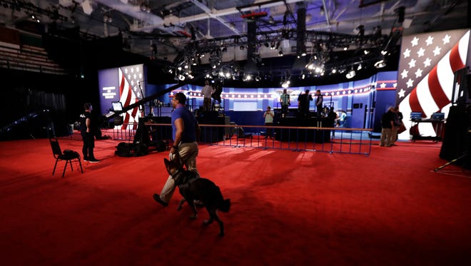 A security officer walks his dog across the debate hall as preparations are made for the second presidential debate Oct. 8, 2016.