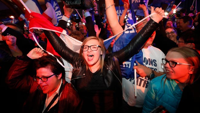 Supporters of far-right leader and candidate for the 2017 French presidential election, Marine Le Pen, celebrate after exit poll results of the first round of the presidential election are announced at election day headquarters in Henin-Beaumont.