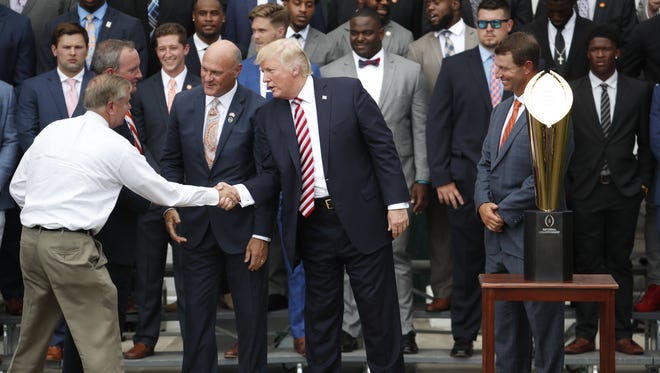 President Donald Trump shakes hands with Sen. Lindsey Graham, R-S.C. on the South Lawn of the White House during a ceremony to celebrate Clemson's football national championship.