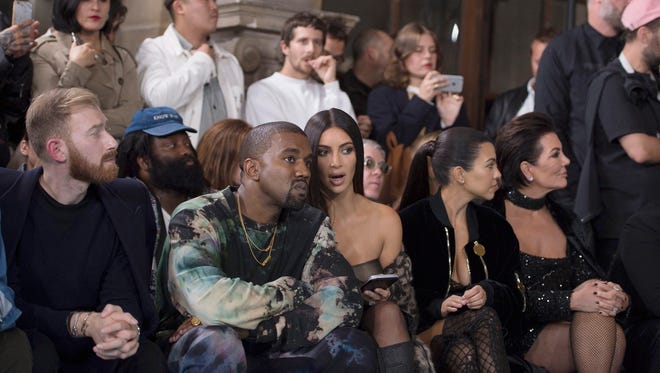 epa05567721 (FILE) A file photograph showing US singer Kanye West (2-L) and wife, US reality television star Kim Kardashian (C), attend the presentation of the Spring/Summer 2017 collection by Off-White during the Paris Fashion Week, in Paris, France, 29 September 2016. Reports on 03 October 2016 state that Kim Kardashian has been held at gunpoint and robbed of jewellery in her Paris hotel room.  Her husband US musician Kanye West stopped his concert in New York on hearing the news.  EPA/CAROLINE BLUMBERG *** Local Caption *** 53043015 ORG XMIT: BOR605