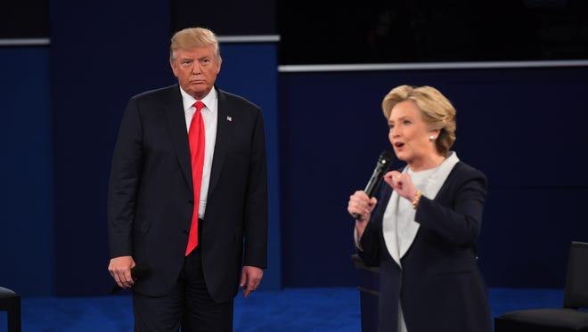 Democratic presidential candidate Hillary Clinton speaks while Republican presidential candidate Donald Trump watches during the second presidential debate at Washington University in St. Louis.