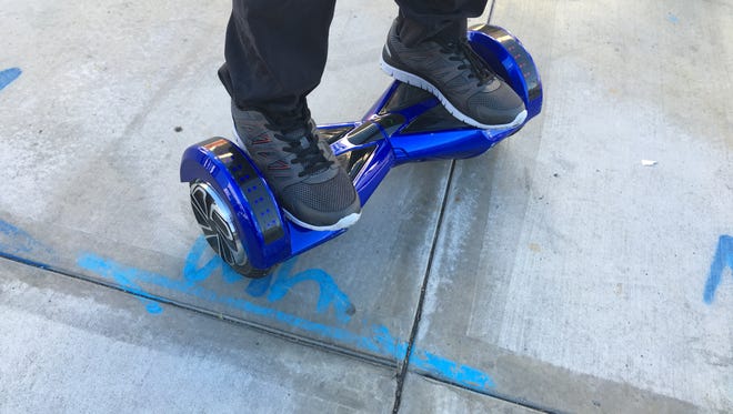 A Manhattan Beach man rides around town on a multi-colored hoverboard, a stand-up, motorized scooter.