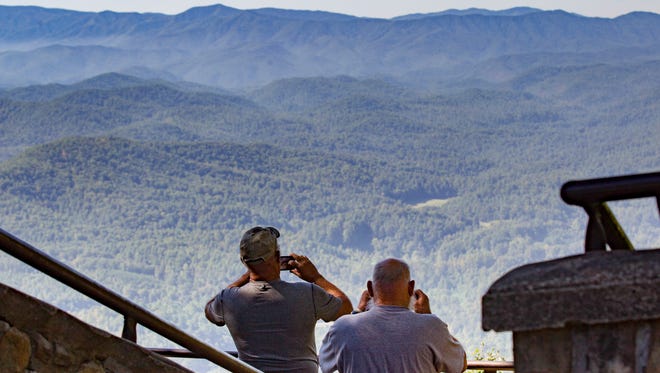 In this Sept. 15, 2016, photo, visitors take pictures of the Great Smoky Mountains National Park from a lookout point on the Foothills Parkway near Chilhowee, Tenn. Work is underway to complete the extension of scenic route running near the northern boundary of the park. (AP Photo/Erik Schelzig) ORG XMIT: TNES104 [Via MerlinFTP Drop]