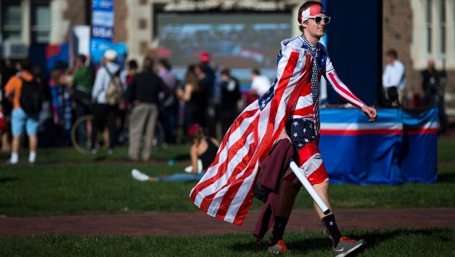 Ryan Delabar, 20, walks across the Washington University in St. Louis campus decked out in American flags before the second presidential debate.