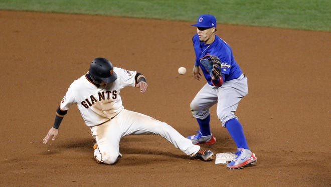 Game 3 in San Francisco:  Giants second baseman Joe Panik slides safely back to second against Cubs second baseman Javier Baez in the 11th inning.