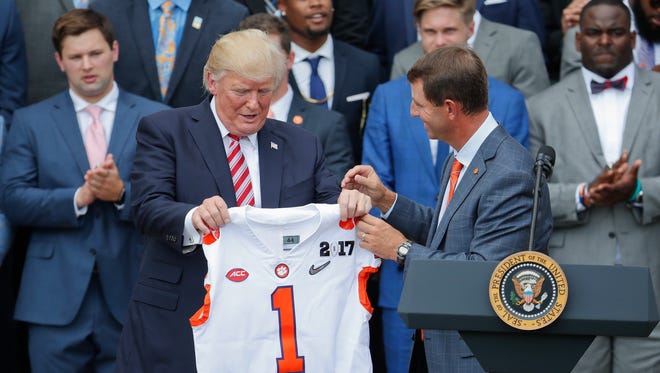 Clemson coach Dabo Swinney presents President Trump with a jersey during the national champion Tigers' visit to the White House.