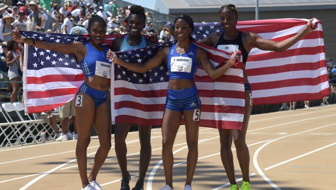Christina Manning, Dawn Harper, Kendra Harrison, and Nia Ali, from left, pose for photos with U.S. flags after running the women's 100 hurdles at the USA track and field championships in Sacramento on Saturday. They will represent the USA in the event at the worlds.