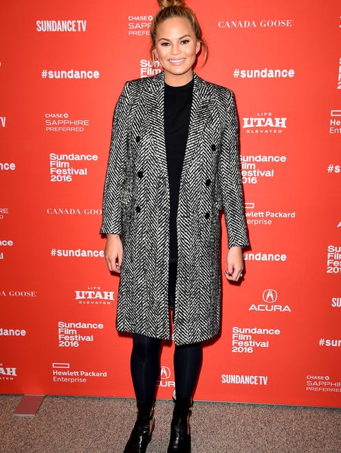 Need a break from showing off the bump in something skintight? Chrissy shows us how a patterned coat can provide some camouflage, wearing a Saint Laurent coat and all-black underneath to Sundance in January.