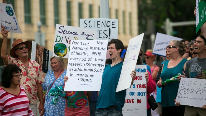 A group in downtown Fort Myers, Fla. yells during the March for Science rally, "What do we want? Science! When do we want it? After peer review!"