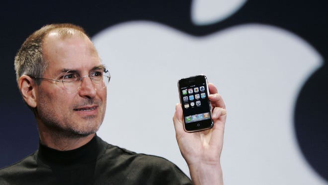 In this Jan. 9, 2007, file photo, Apple CEO Steve Jobs holds up an iPhone at the Macworld Conference in San Francisco.