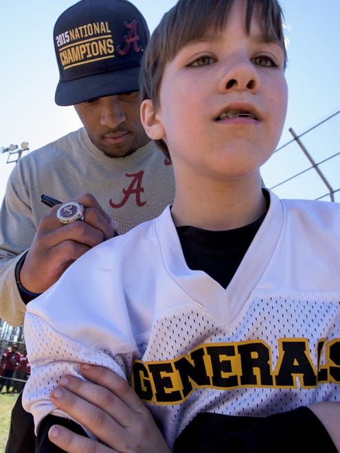 CFB National Championship Game MVP O.J. Howard signs an Autauga Academy jersey for Aaron Powell as the town of Autaugaville, Ala. holds a parade in honor of Howard on Saturday February 27, 2016.