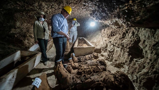 Egyptian Antiquities Minister Khaled el-Enany, center, speaks to the media on May 13, 2017, in front of mummies following their discovery in catacombs in the Touna el-Gabal district of the Minya province, in central Egypt.