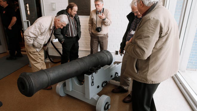 Visitors view an 18th-Century British cannon found in the Detroit River in 2011 while on display, following a three-year restoration, at the Dossin Great Lakes Museum in Detroit Wednesday, Dec. 10, 2014.