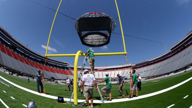 Workers install the second goal post as the transformation of Bristol Motor Speedway from a NASCAR track to a football stadium.