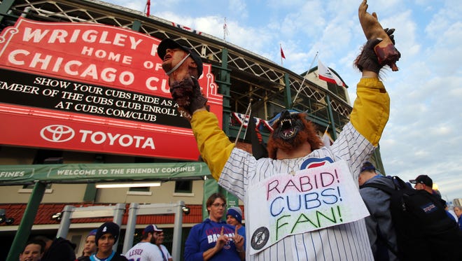 Game 1 in Chicago:  A Cubs fan dressed as a werewolf poses for a photo in front of Wrigley Field.