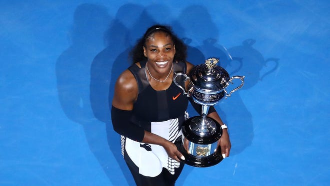 Serena Williams poses with the 2017 Australian Open trophy after defeating her sister Venus 6-4, 6-4 in the final.