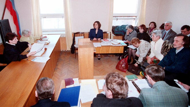 In this 1999 file photo, a group of Jehovah's Witnesses, right, sit in court during their trial in Moscow when a Moscow court sought to ban the religious group.