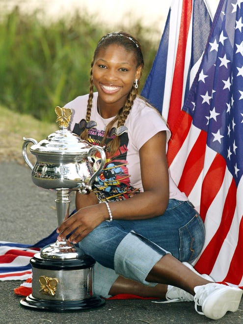Serena Williams  poses for pictures with the 2003 Australian Open women's singles trophy on the banks of the Yarra River following her win. Serena beat her sister Venus 7-6, 3-6, 6-4 in the final.